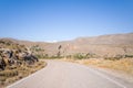 An asphalt road in the middle of arid and rocky mountains , in Europe, Greece, Crete, Kato Zakros, By the Mediterranean Sea, in Royalty Free Stock Photo