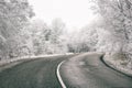 Asphalt road on a mountain pass in winter, scenic landscape with white frosted trees. Outdoor travel or transportation background Royalty Free Stock Photo