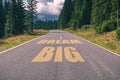 Asphalt road in the mountains going straight up with dream big t Royalty Free Stock Photo