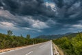 Asphalt road panorama in countryside on cloudy day. Road in forest under dramatic cloudy sky. Royalty Free Stock Photo