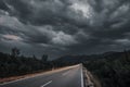 Asphalt road panorama in countryside on cloudy day. Road in forest under dramatic cloudy sky. Royalty Free Stock Photo