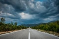 Asphalt road panorama in countryside on cloudy day. Road in forest under dramatic cloudy sky. Royalty Free Stock Photo