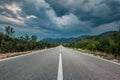 Asphalt road panorama in countryside on cloudy day. Road in forest under dramatic cloudy sky. Royalty Free Stock Photo