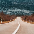 Asphalt road panorama in countryside on cloudy day. Road in forest under dramatic cloudy sky. Royalty Free Stock Photo