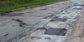 Asphalt road repair of poor quality. Pothole asphalt road repairs. A newly patched roadway in a bad condition Royalty Free Stock Photo