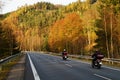 Asphalt road with a ride motorcycles in the autumn landscape Royalty Free Stock Photo