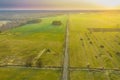 Asphalt road running through meadows and fields.