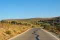 Asphalt road with shadow leading through countryside Royalty Free Stock Photo