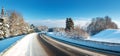 Asphalt road in snowy winter on beautiful sunny day