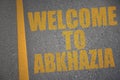 asphalt road with text welcome to abkhazia near yellow line.