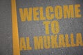 asphalt road with text welcome to Al Mukalla near yellow line Royalty Free Stock Photo