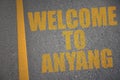asphalt road with text welcome to Anyang near yellow line