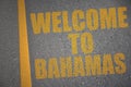 asphalt road with text welcome to bahamas near yellow line.