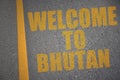 asphalt road with text welcome to bhutan near yellow line.