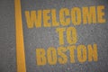 asphalt road with text welcome to Boston near yellow line