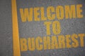 asphalt road with text welcome to Bucharest near yellow line