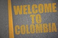 asphalt road with text welcome to colombia near yellow line.