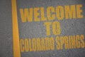 asphalt road with text welcome to colorado springs near yellow line Royalty Free Stock Photo