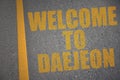 asphalt road with text welcome to Daejeon near yellow line