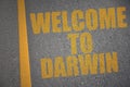 asphalt road with text welcome to Darwin near yellow line