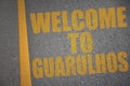 asphalt road with text welcome to Guarulhos near yellow line