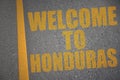 asphalt road with text welcome to honduras near yellow line.