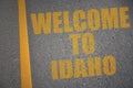 asphalt road with text welcome to idaho near yellow line. Royalty Free Stock Photo