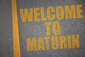asphalt road with text welcome to Maturin near yellow line