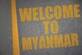 asphalt road with text welcome to myanmar near yellow line.