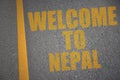 Asphalt road with text welcome to nepal near yellow line.
