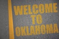 asphalt road with text welcome to oklahoma near yellow line.