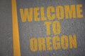 asphalt road with text welcome to oregon near yellow line.