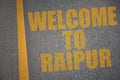 asphalt road with text welcome to Raipur near yellow line