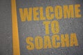 asphalt road with text welcome to Soacha near yellow line