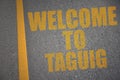asphalt road with text welcome to Taguig near yellow line