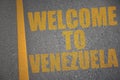 asphalt road with text welcome to venezuela near yellow line.