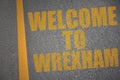 asphalt road with text welcome to Wrexham near yellow line