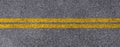 Double yellow lines on asphalt street roadway surface texture background. Royalty Free Stock Photo