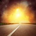 Asphalt road to horizon and sunset in dramatic clouds Royalty Free Stock Photo