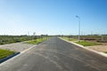 Asphalt road between vacant lands in a new residential suburb. Tarneit, Melbourne, VIC Australia. Royalty Free Stock Photo