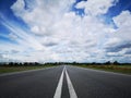 Asphalt road vanishing point with blue sky. Royalty Free Stock Photo