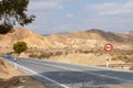 Asphalt road on which a car circulates through the arid landscape of the Tabernas desert. Royalty Free Stock Photo