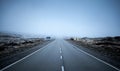 Asphalt road with a winding road sign on a foggy day Royalty Free Stock Photo