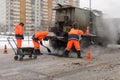 Asphalt road workers in a small pit on the highway