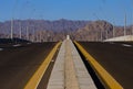Asphalt roadbed stretching into the distance with mountains and sky, Sinai, Egypt