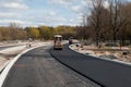 Asphalt rollers paving new asphalt driving in line one near another. New road construction. Selective focus. Royalty Free Stock Photo