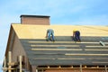 Asphalt roofing shingles. Building contractors laying bitumen waterproofing membrane berofe laying asphalt shingles roofing. Royalty Free Stock Photo