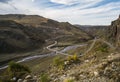 The asphalt serpentine track winds and meanders along the mountain slope and valley