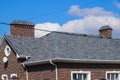 Asphalt . Decorative bitumen shingles on the roof of a brick house Royalty Free Stock Photo
