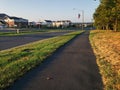 Asphalt Sidewalk runs along the road, Yellowed lawns at dawn